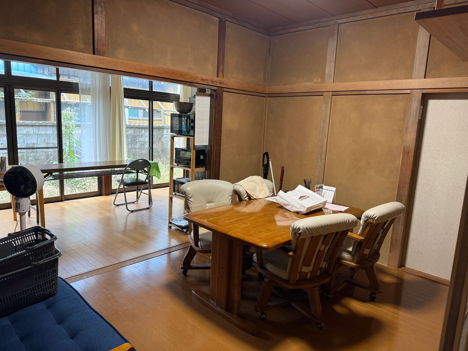 庭に面した大きな窓と、木のテーブルといすがある談話室